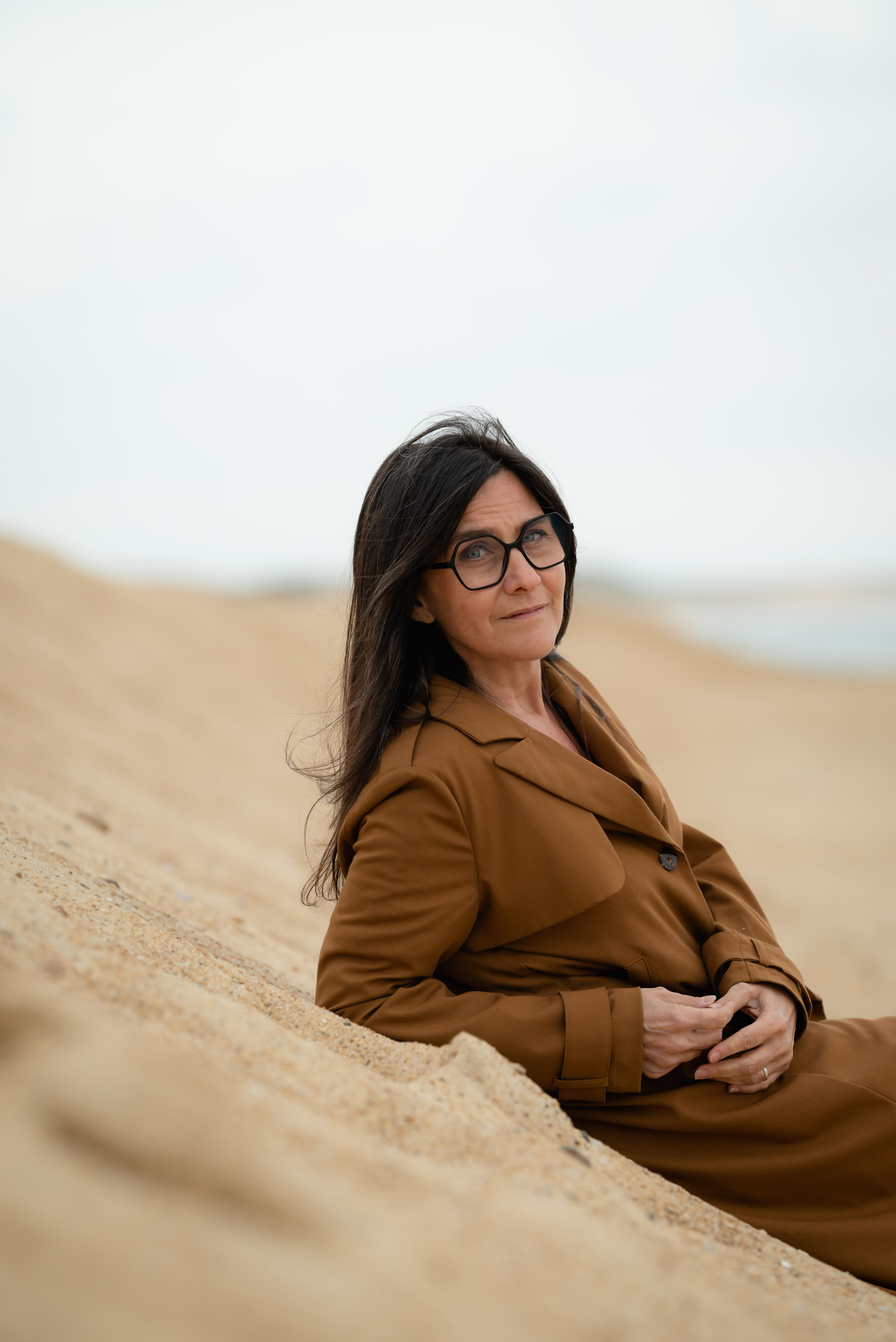 Sandrine souriante, assise dans les dunes
