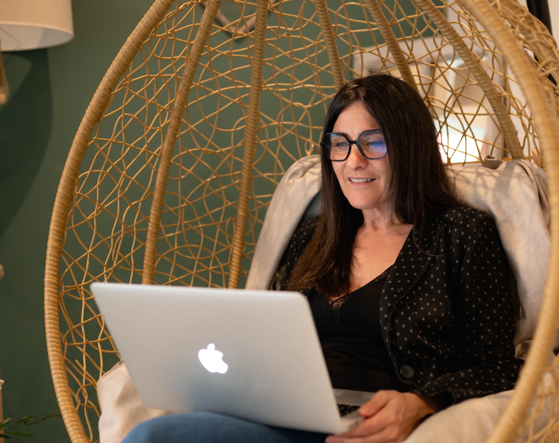Sandrine souriante dans un fauteuil en rotin
